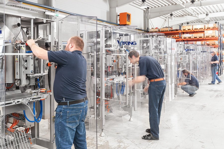 two men working on packaging machine service maintenance