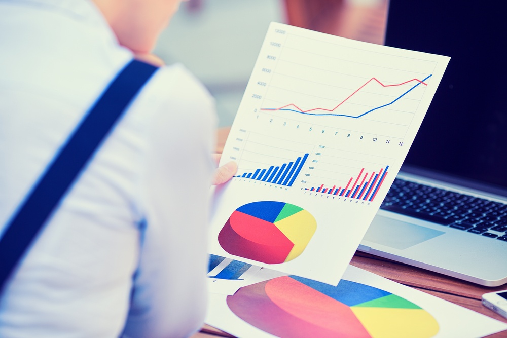 woman investment consultant analyzing company annual financial report balance sheet statement working with documents graphs. Stock market, office, tax, education concept. Hands with charts papers .jpeg